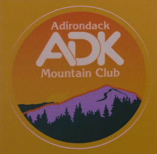 Image of a sticker with the ADK logo in white, orange backgound, and purple mountain.