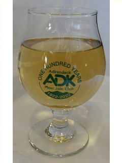 Belgian style beer glass with green ADK Centennial logo