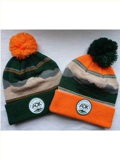 twoknot hats, one has orange band with green pom, the other has a green band with orange pom