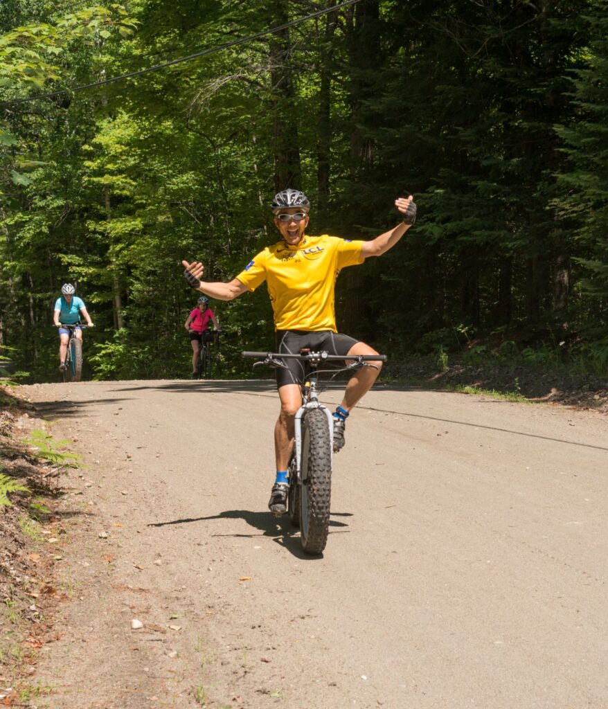 A happy cyclist on a dirt road