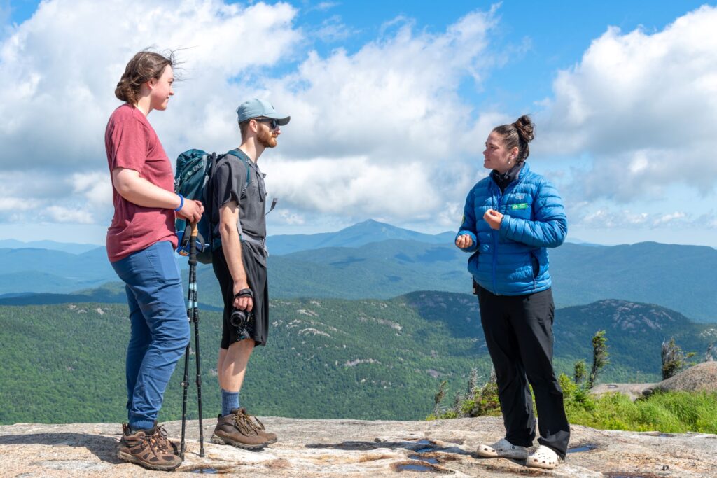 Three people talking on a summit