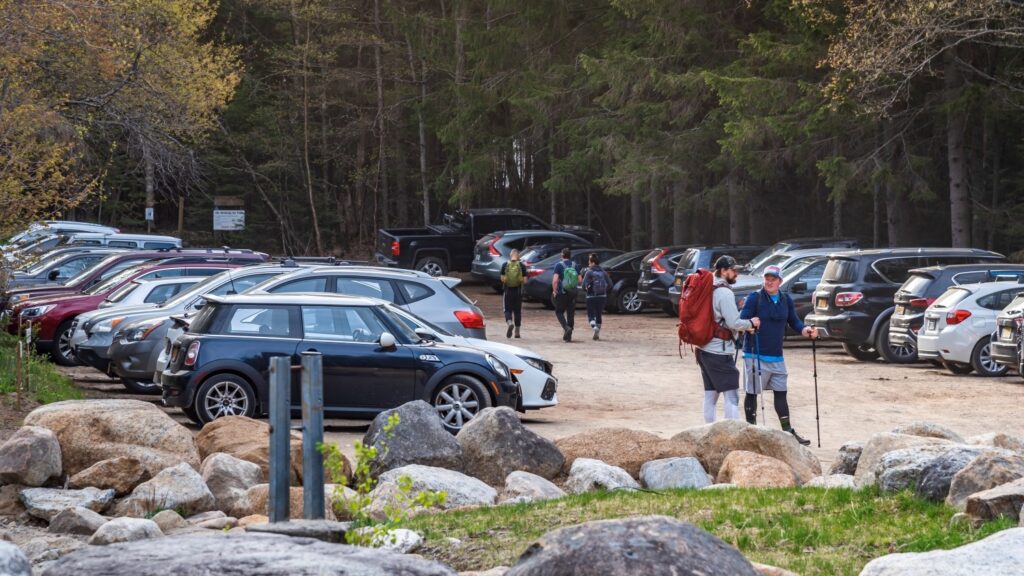 People standing in a full parking lot