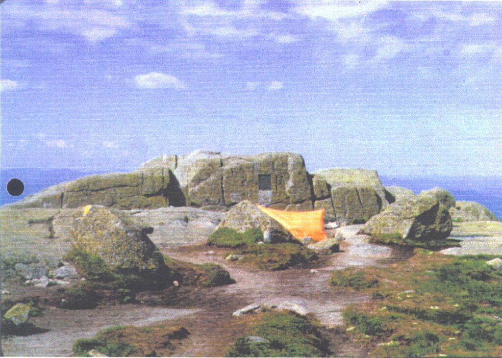 A tent on a rocky mountain summit