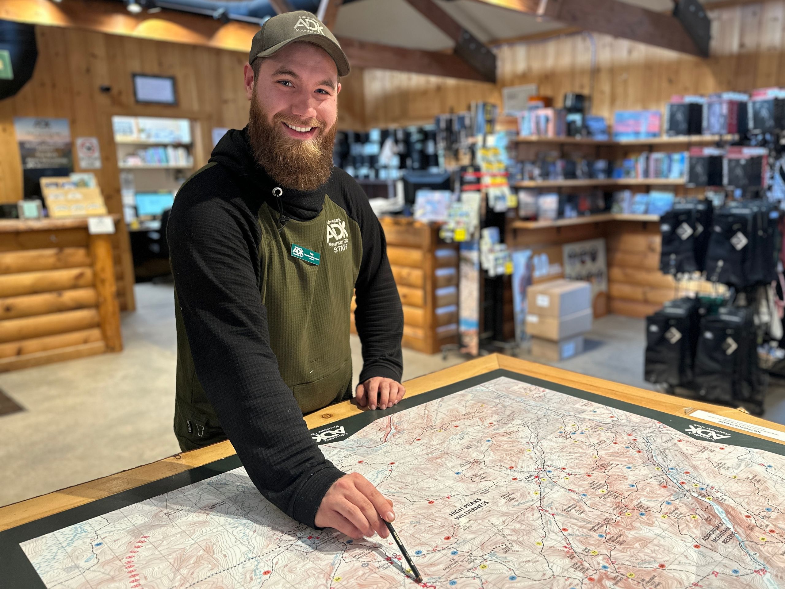 man smiling and pointing at a map table