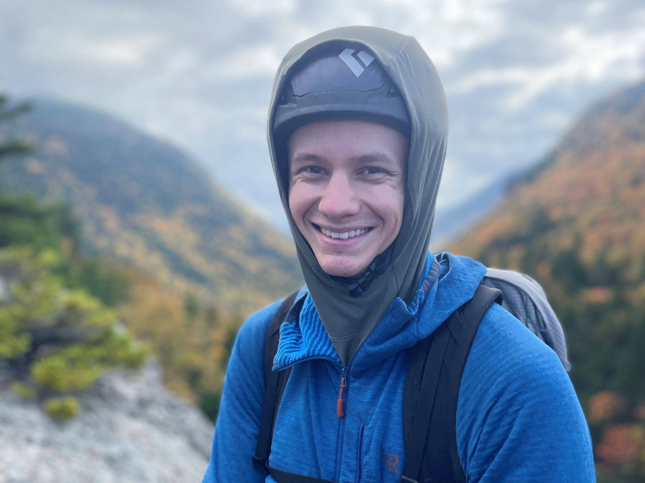 portrait phone of a man on a summit wearing a hemlet