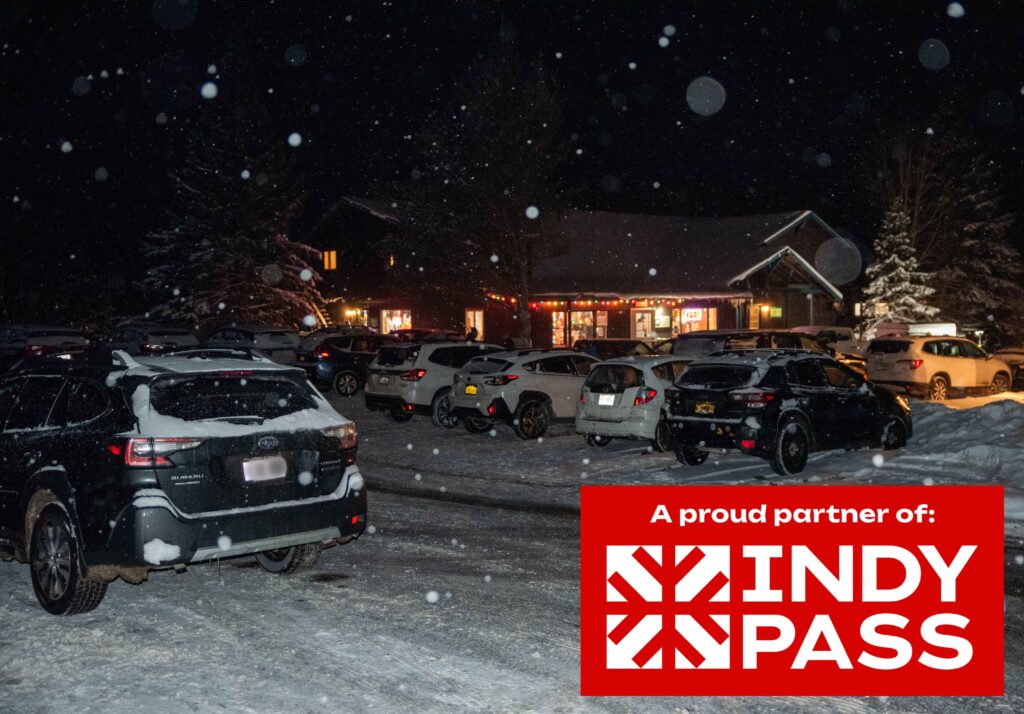 cascade welcome center at night with indy pass proud partner logo