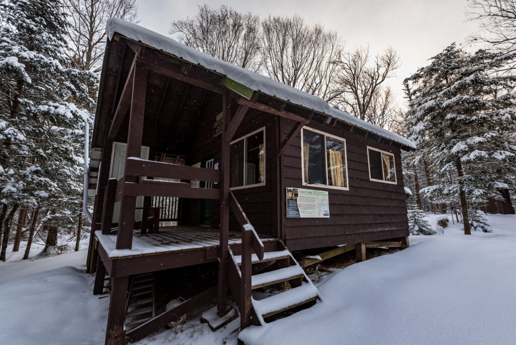 a wilderness cabin in the adirondacks with snow on the ground