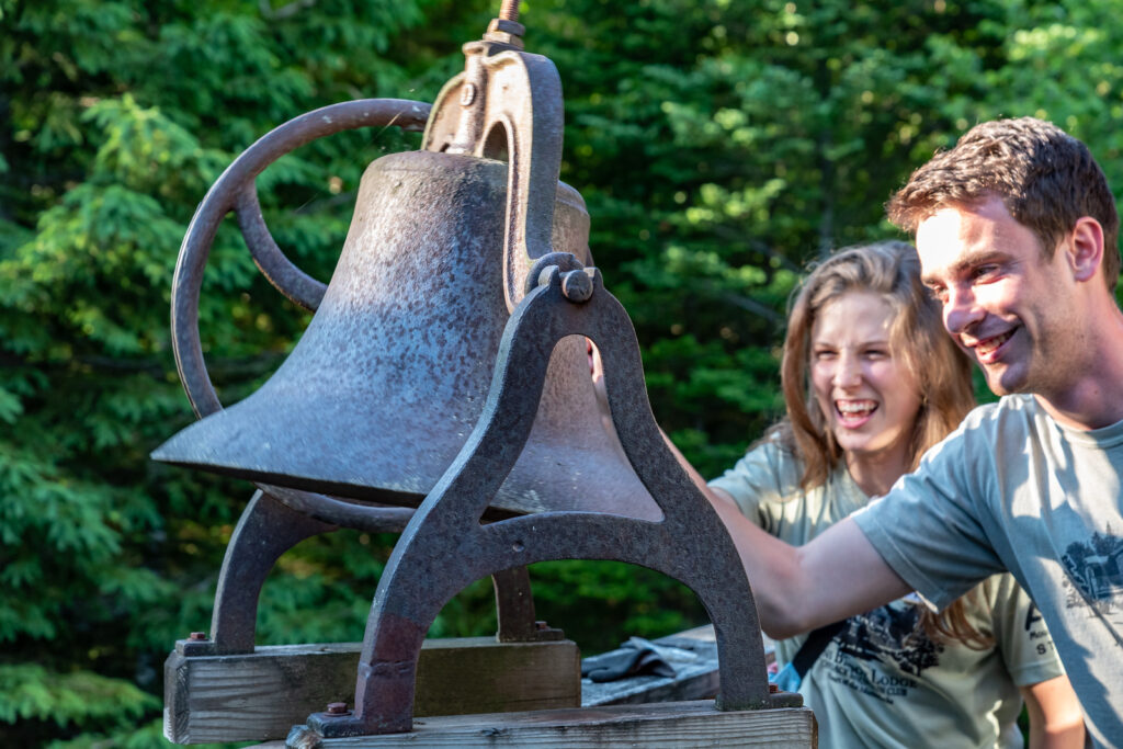 two people ringing the breakfast bell at johns brook lodge