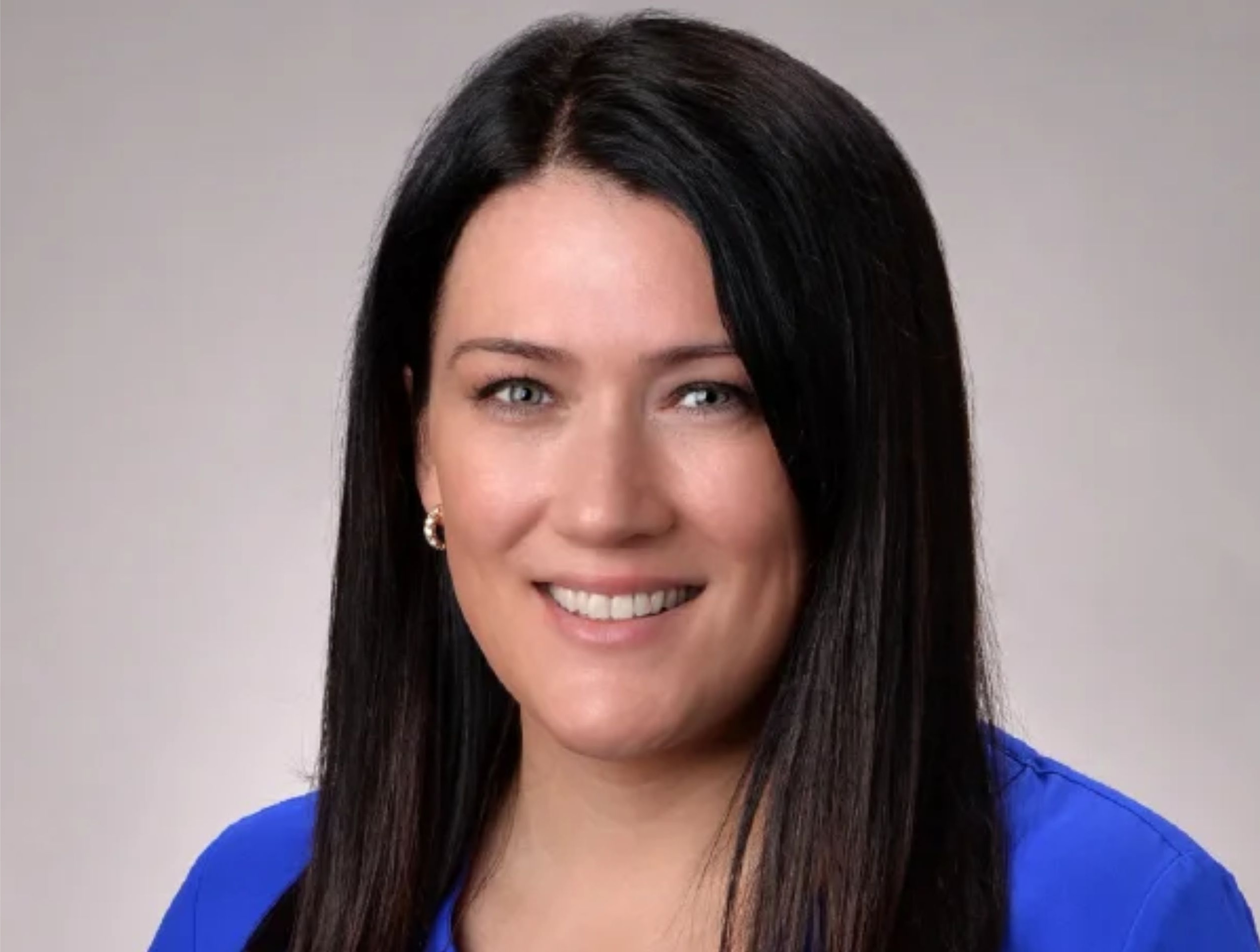 headshot of a woman with dark hair wearing a blue shirt