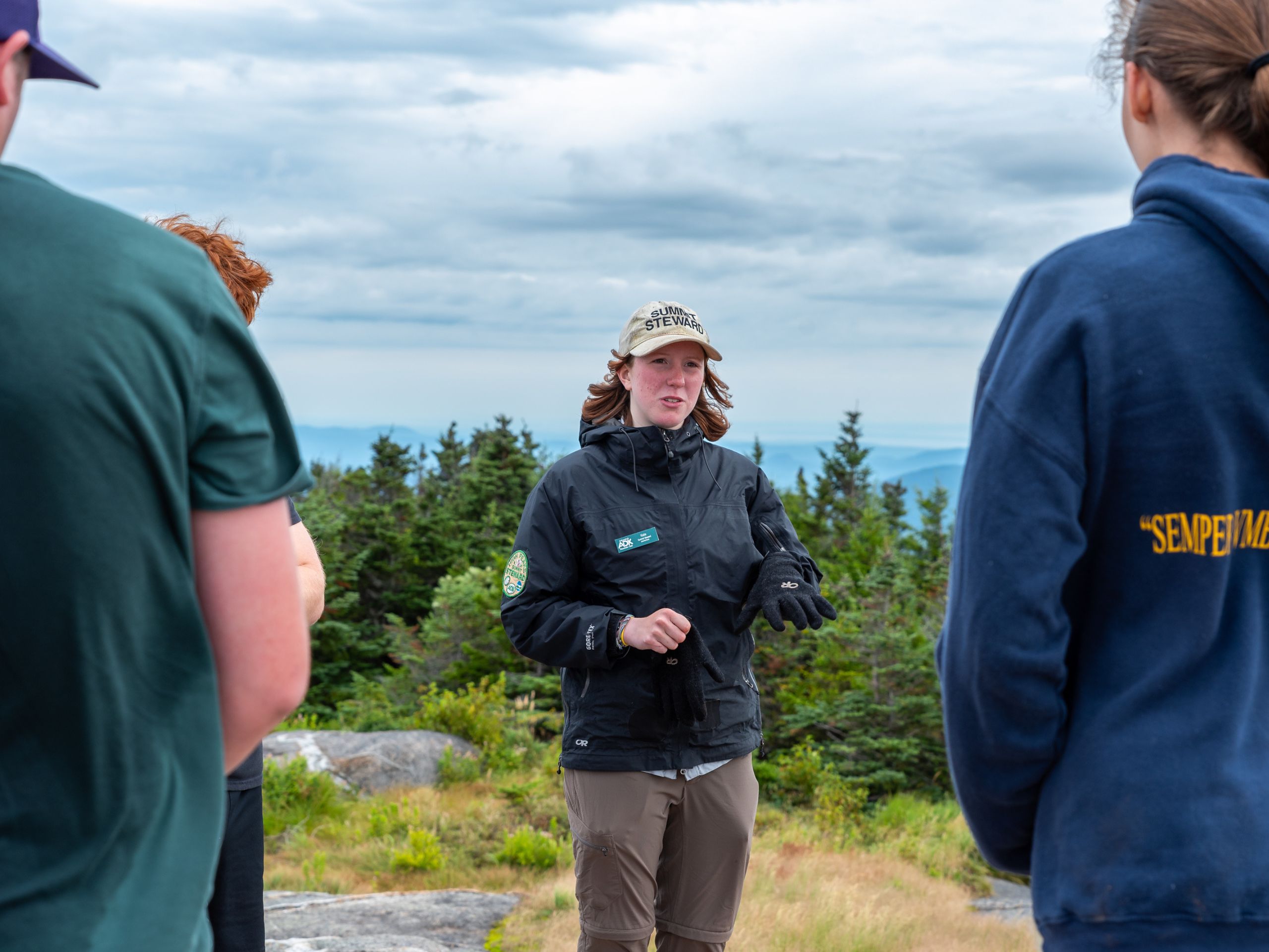 a summit steward speaks to a group of hikers