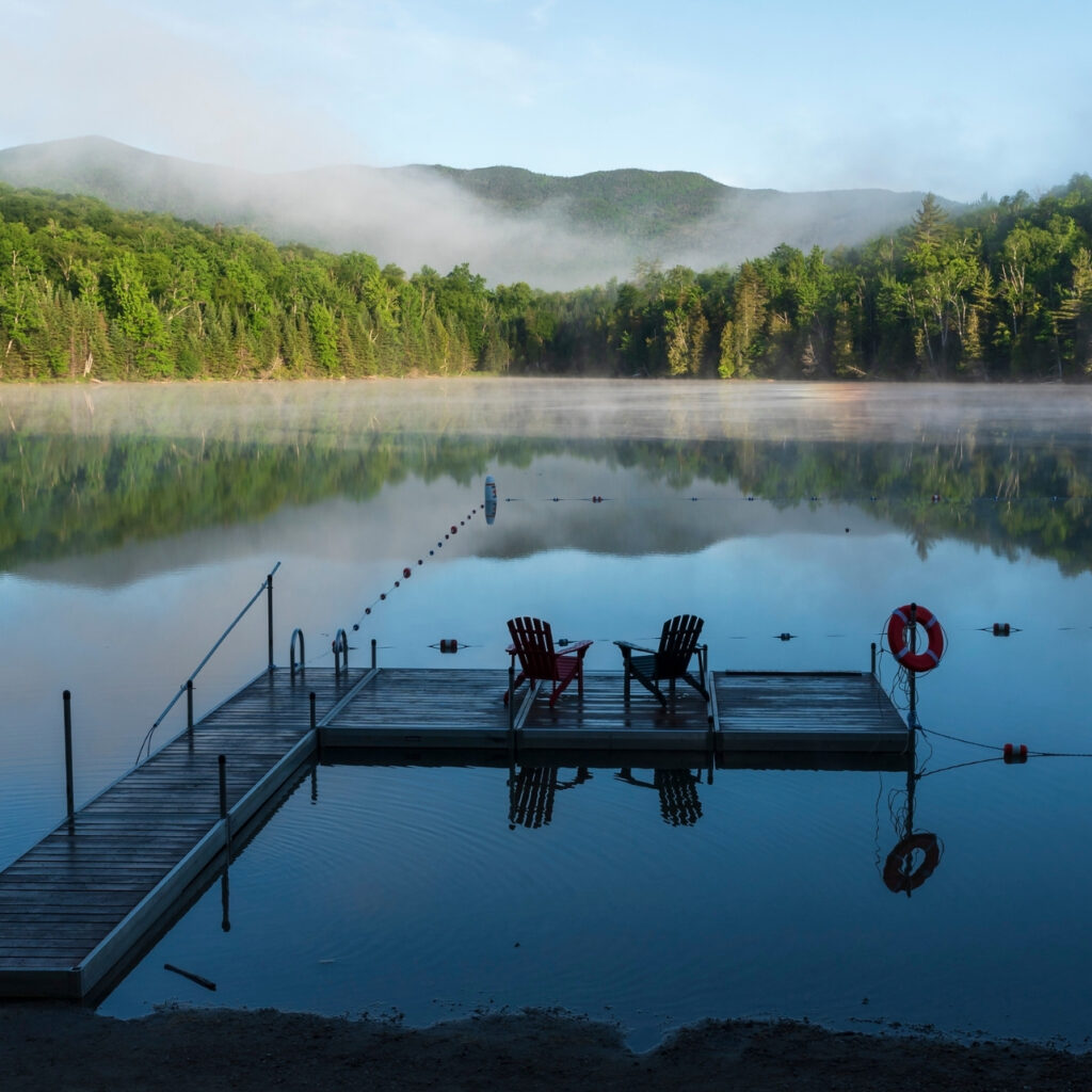 Adirondack chairs on a deck at heart lake in the adirondacks