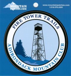 Circular badge for Fire Tower Trails with the Adirondack Mountain Club, featuring a metal fire tower over blue hills.
