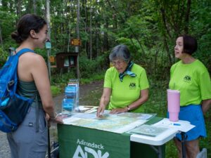 two trailhead stewards speak to a hiker at Buck Mountain
