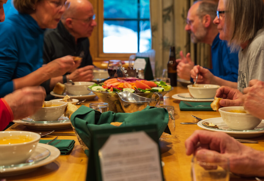 people dining family style at tables in ADK Loj dining room