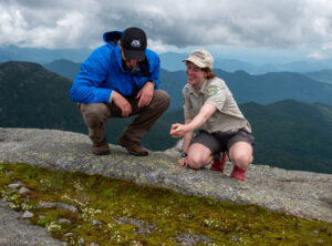 a summit steward speaks to a hiker on a mountain summit