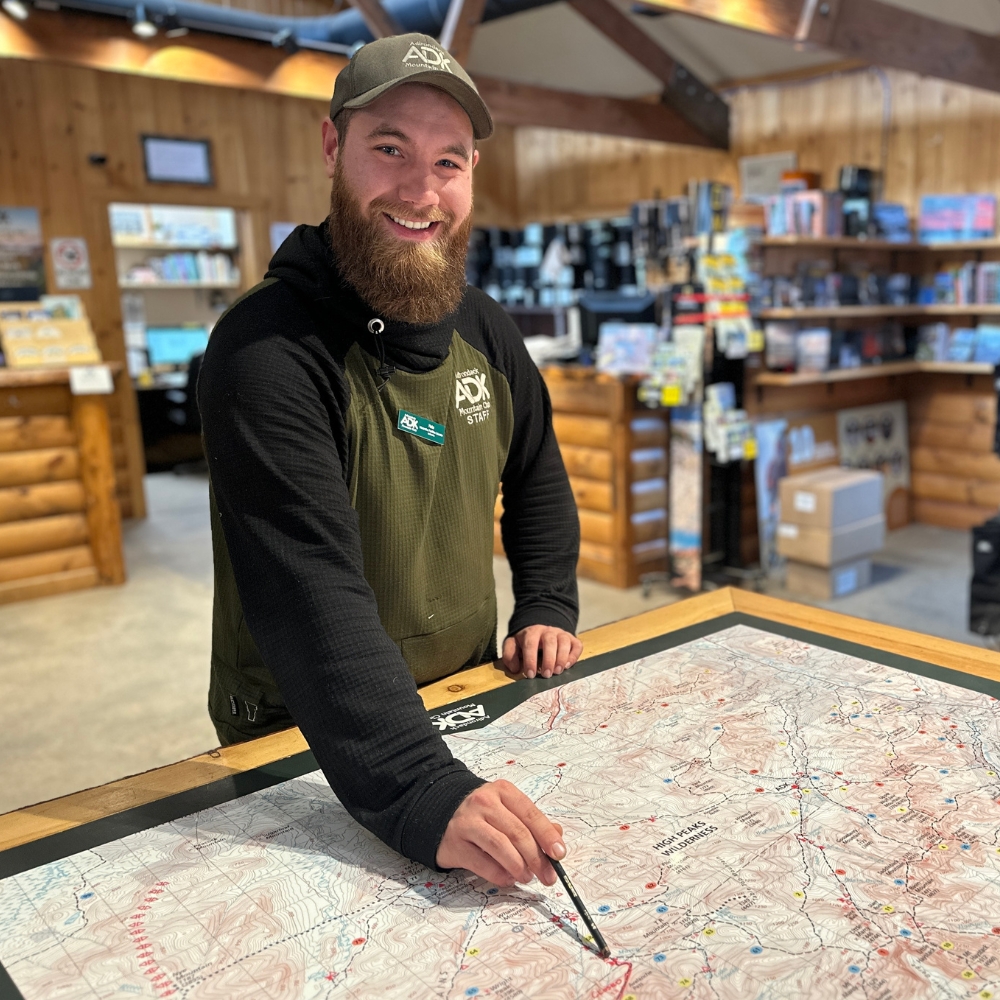 ADK staff member pointing to a map on the map table in the HPIC