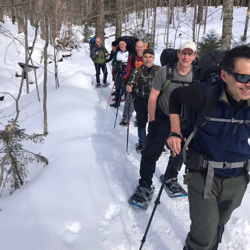 a group of snowshoers hiking on a winter trail