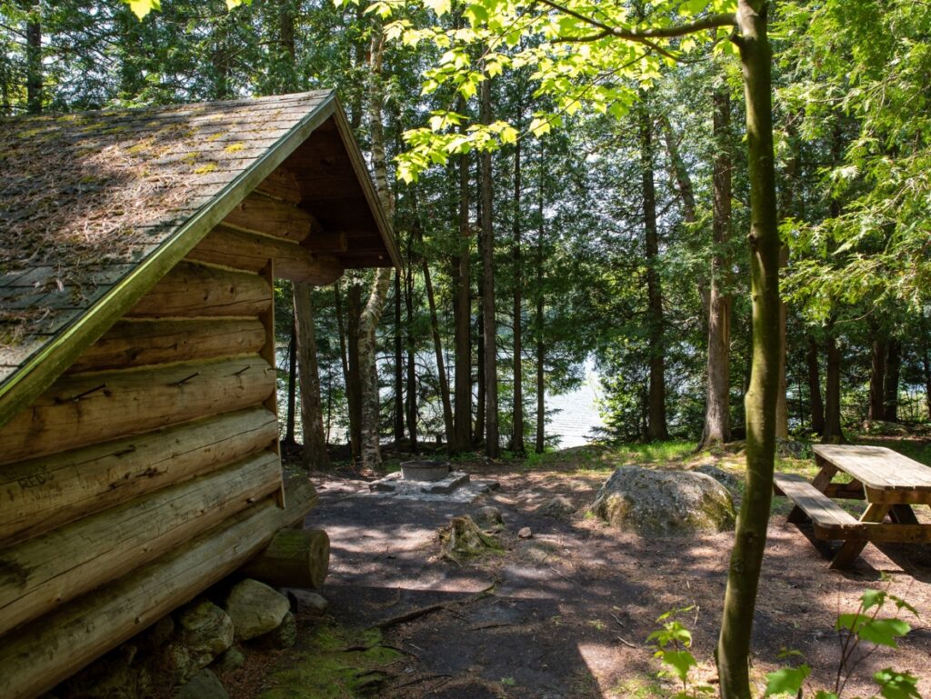an Adirondack lean-to near a lake