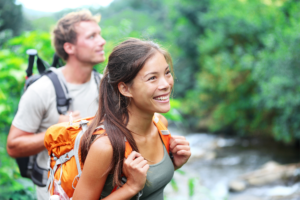 Man and Woman hiking by a stream in the woods