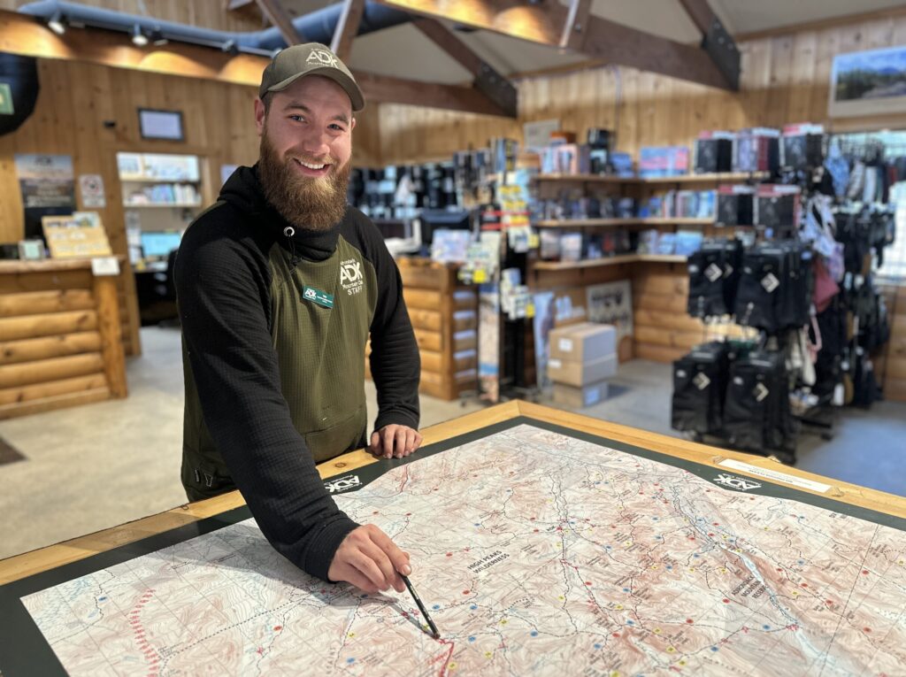 man points at a map table