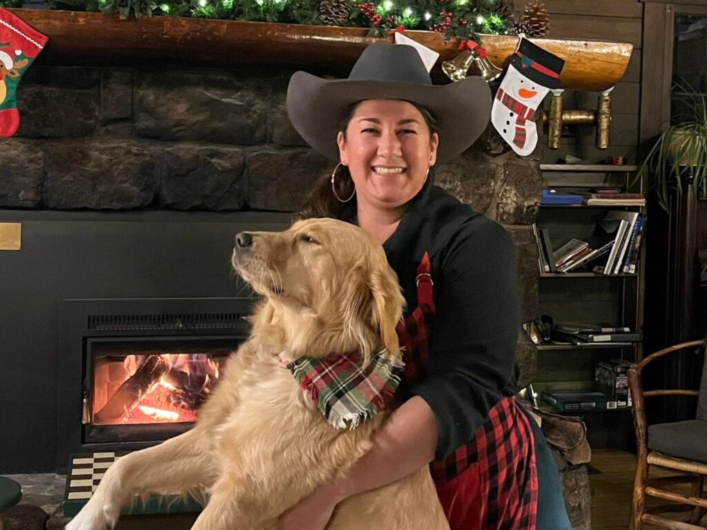 woman in a cowboy hat holding a dog