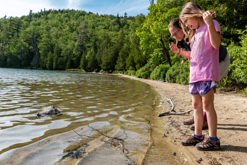 Mother and daughter exploring on the shores of heart lake