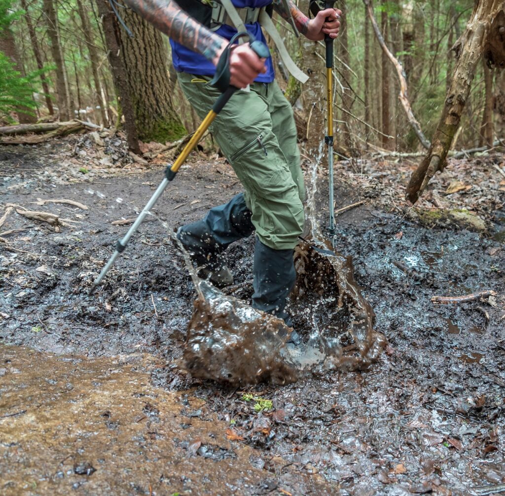hiker walks through deep mud