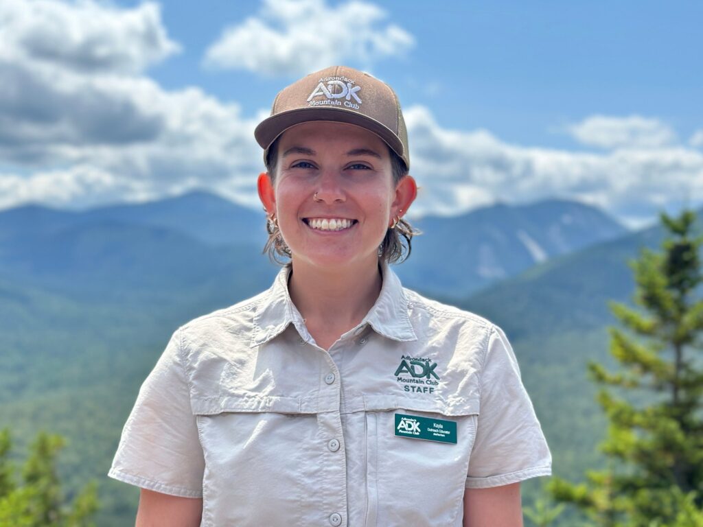 portrait of a smiling woman wearing a hat at the summit of Mount Jo