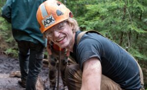 trail crew worker in a hard hat smiling at the camera