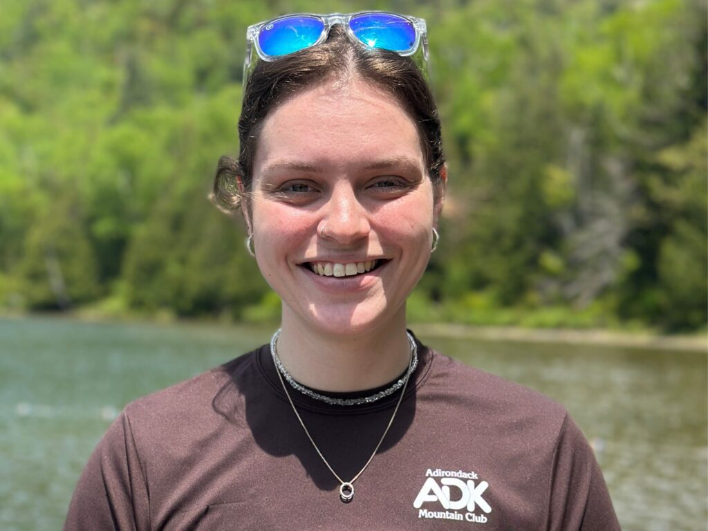 portrait of woman standing in front of a lake