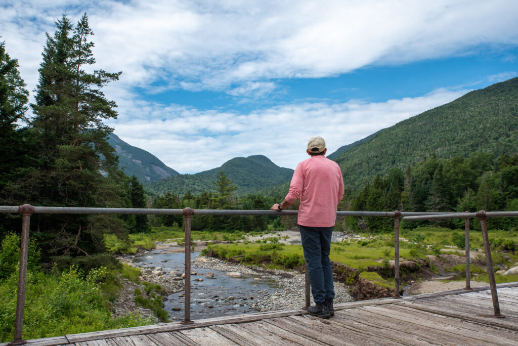 man looks out over marcy dam