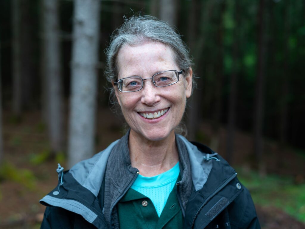 woman wearing glasses with wooded background