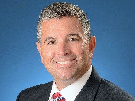 headshot of a man wearing a suit