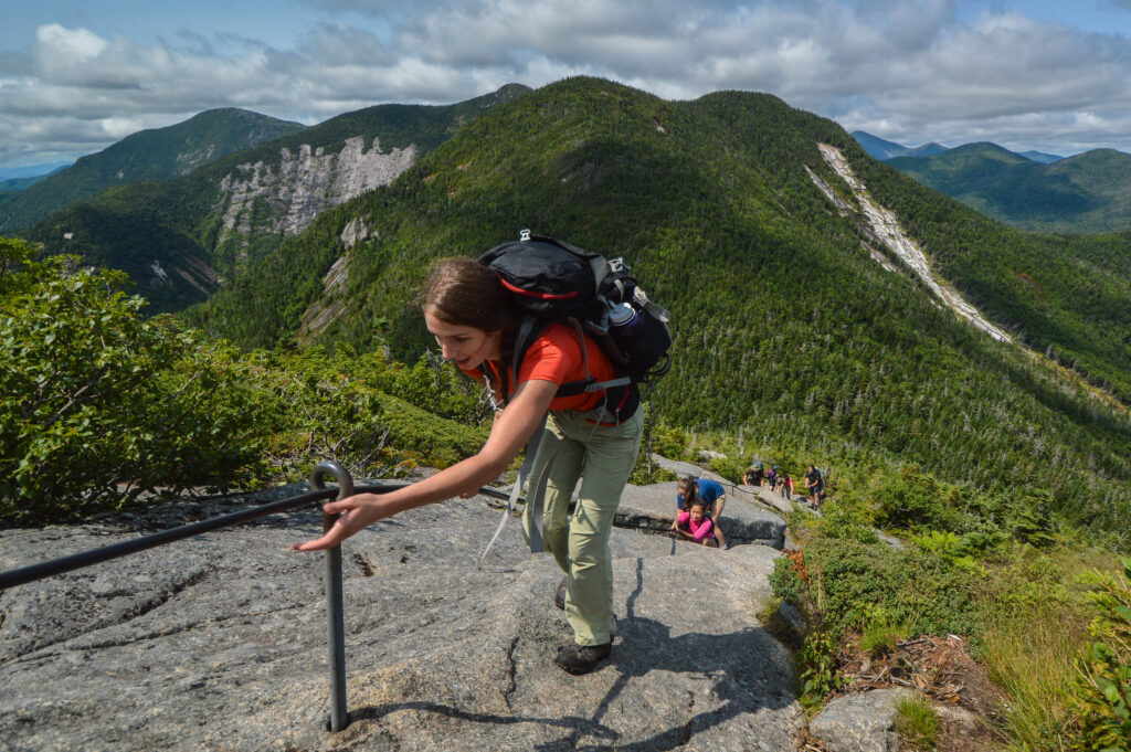 teen adventure hiking up mountain using cable