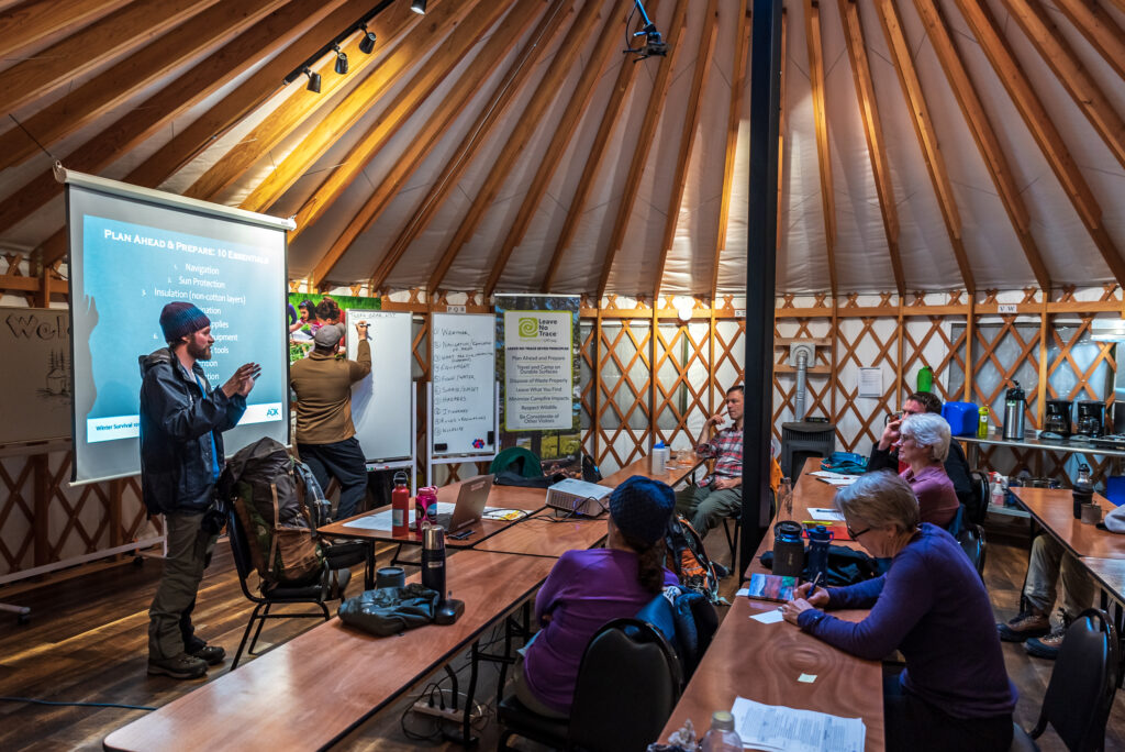 man gives presentation on winter survival in education yurt
