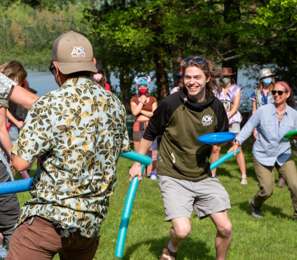 adk staff participating in an ice breaker with frisbees and pool noodles