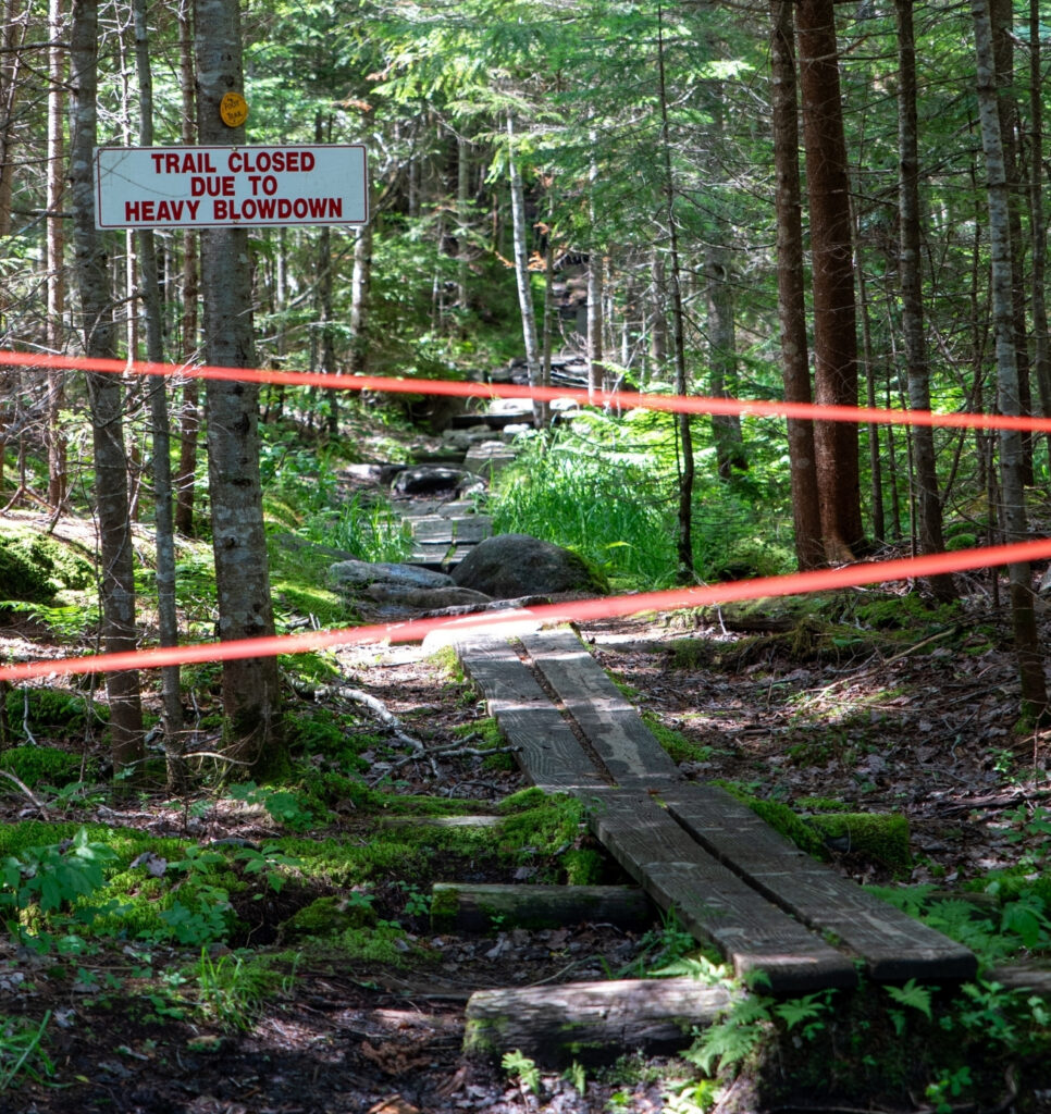 a roped off trail with a trail closed sign