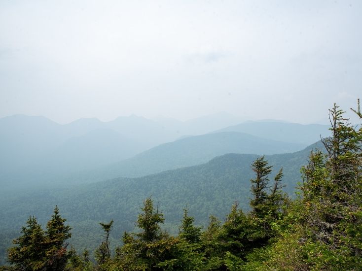 view from big slide in the adirondacks with wildfire smoke in the air making the landscape look hazy