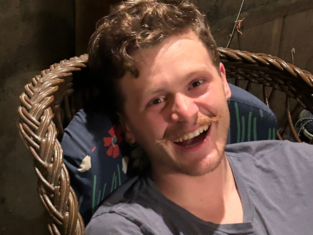 headshot of a smiling man with a mustache