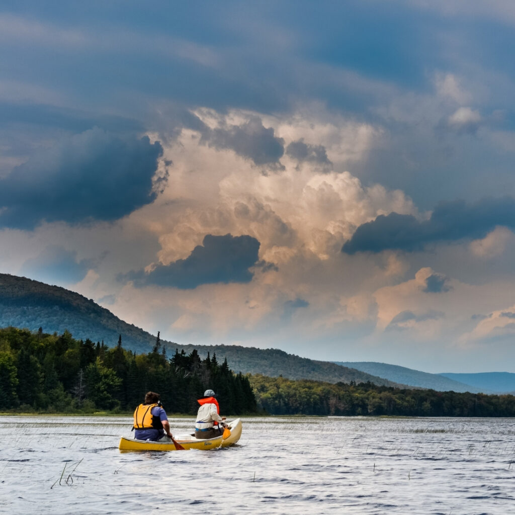 two paddlers in the adirondacks on a cloudy day