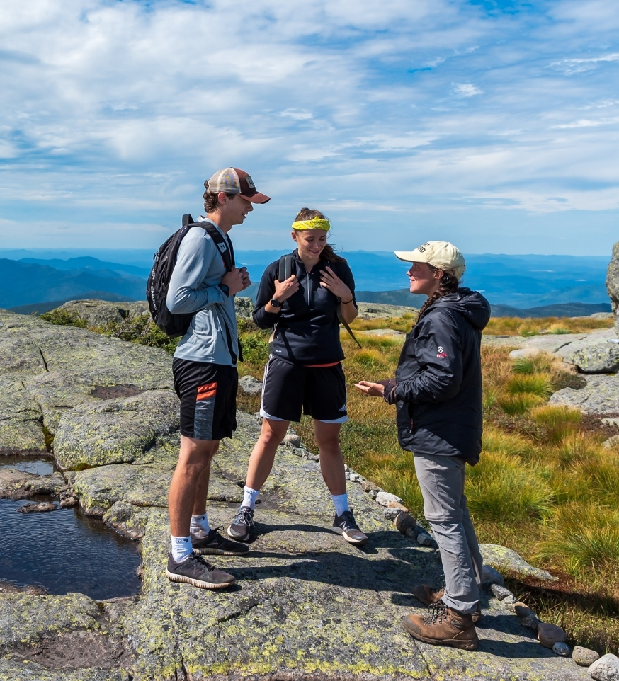 summit steward talking to two hikers in the morning