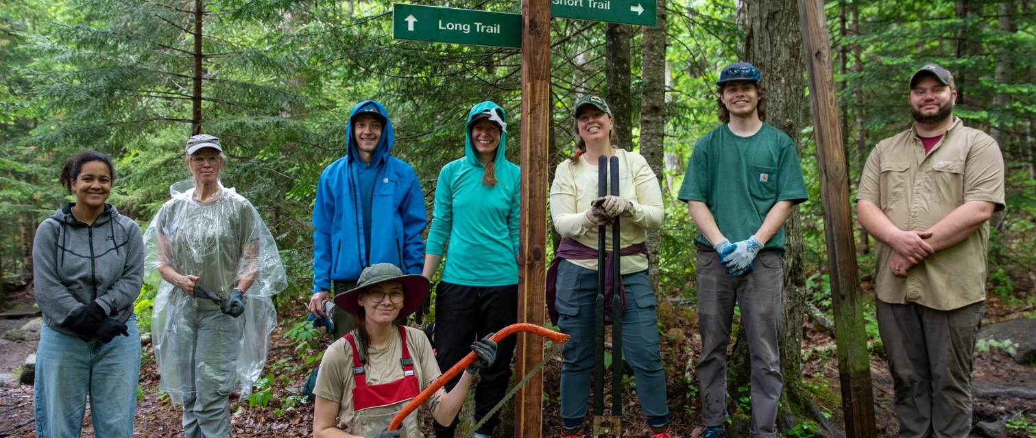 a group of volunteers pose in front of a newly installed sign post on trail to mount jo in the adirondacks