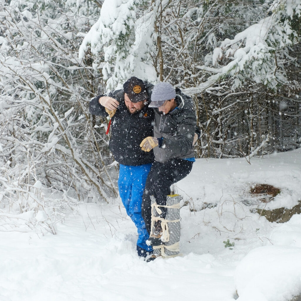 two participants in a wilderness first responder course in winter
