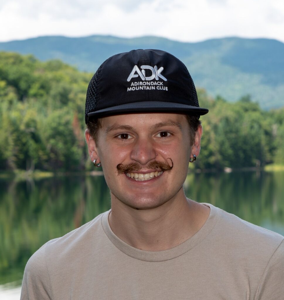 man with mustache wearing an ADK black rogue logo hat
