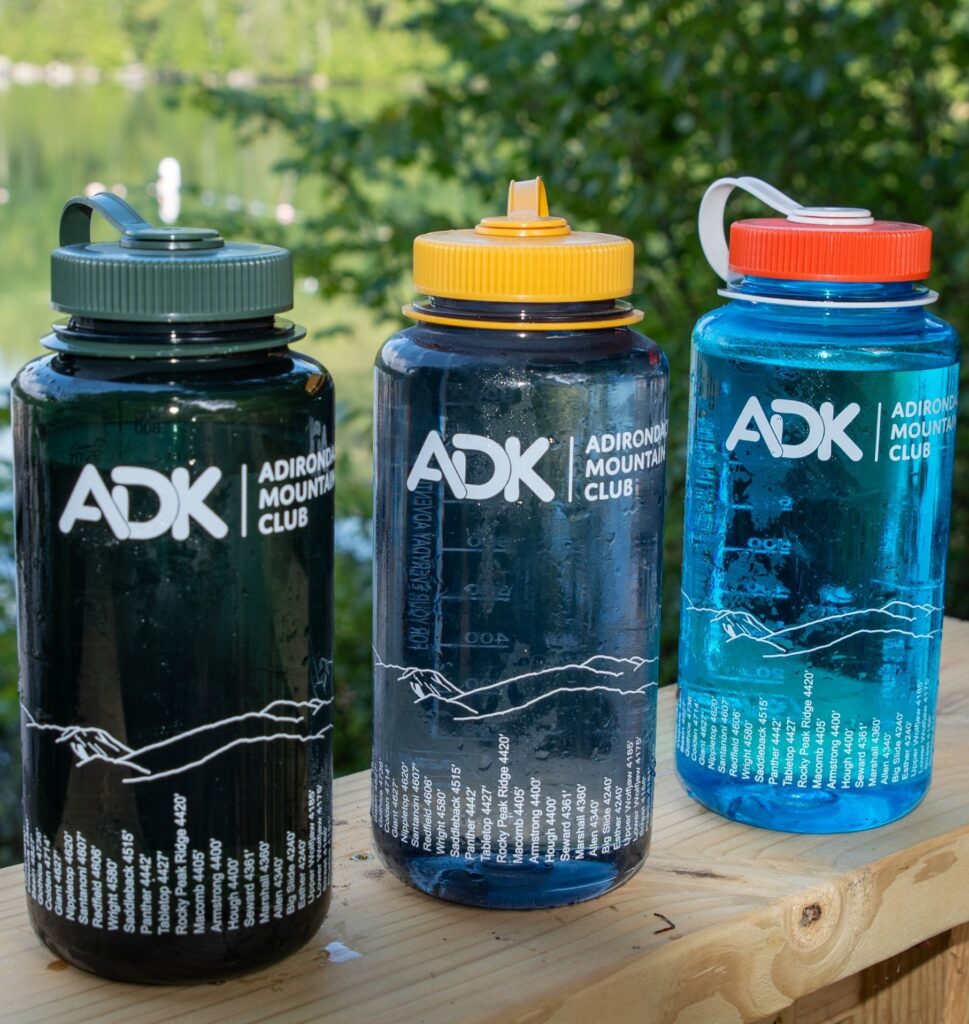 three Nalgene water bottles on a wood ledge