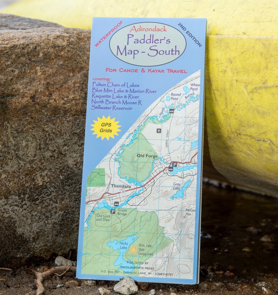 adirondack paddler's map south leaning against a rock and yellow canoe