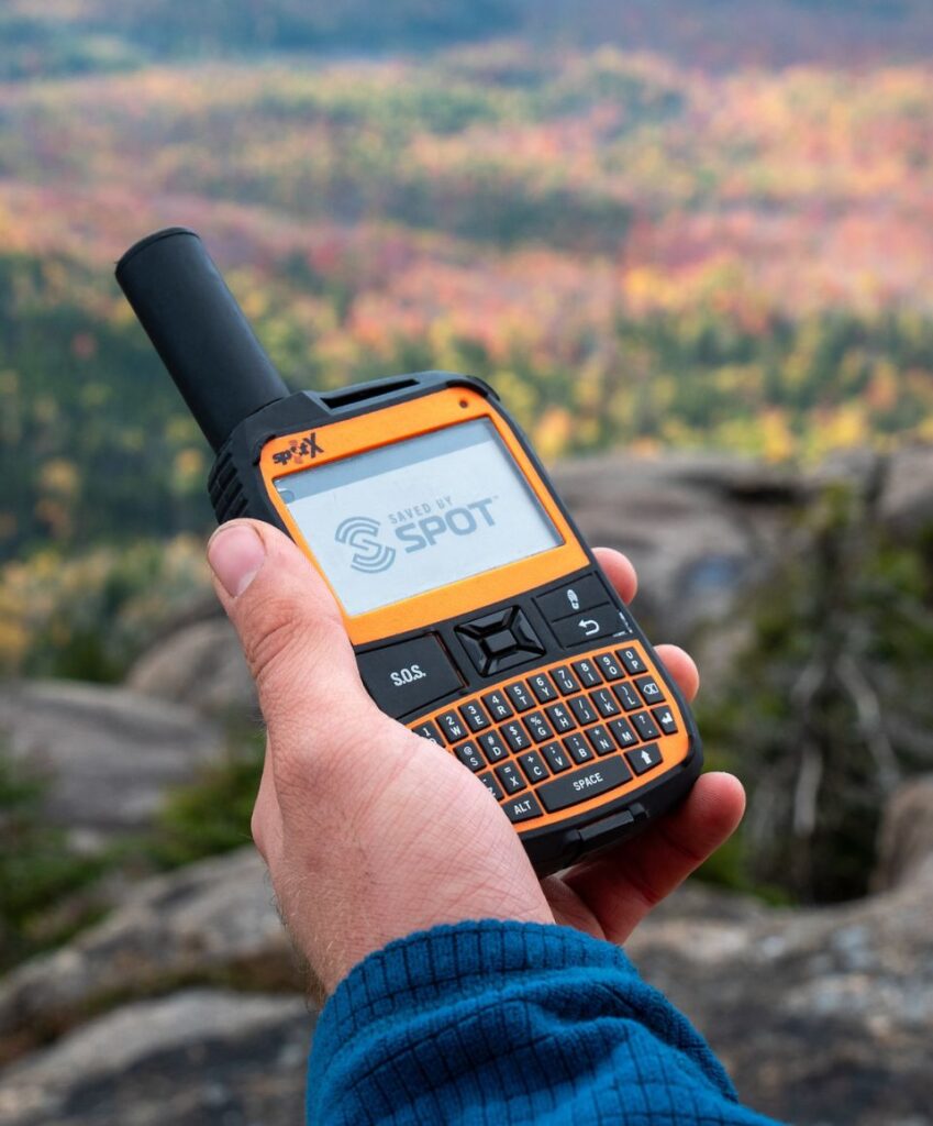 hiker turning on a satellite communication device